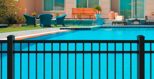 Black aluminum fence beside a swimming pool